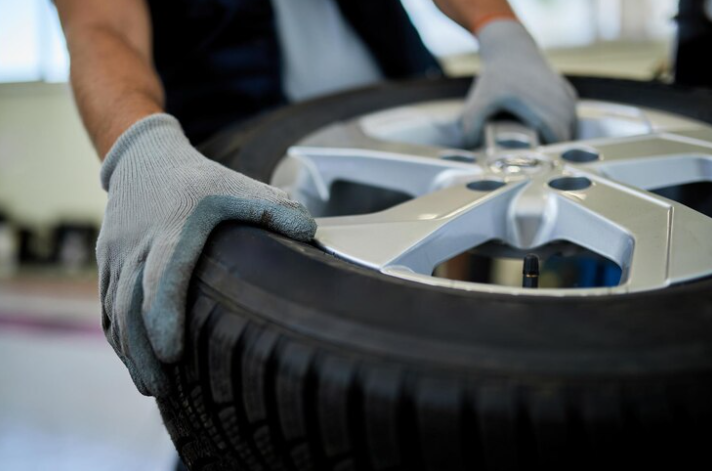 Free Photo Free photo closeup of a mechanic working with car tire in auto repair shop