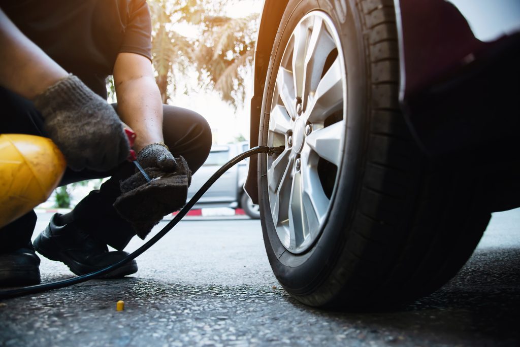 technician is inflate car tire car maintenance service transportation safety concept